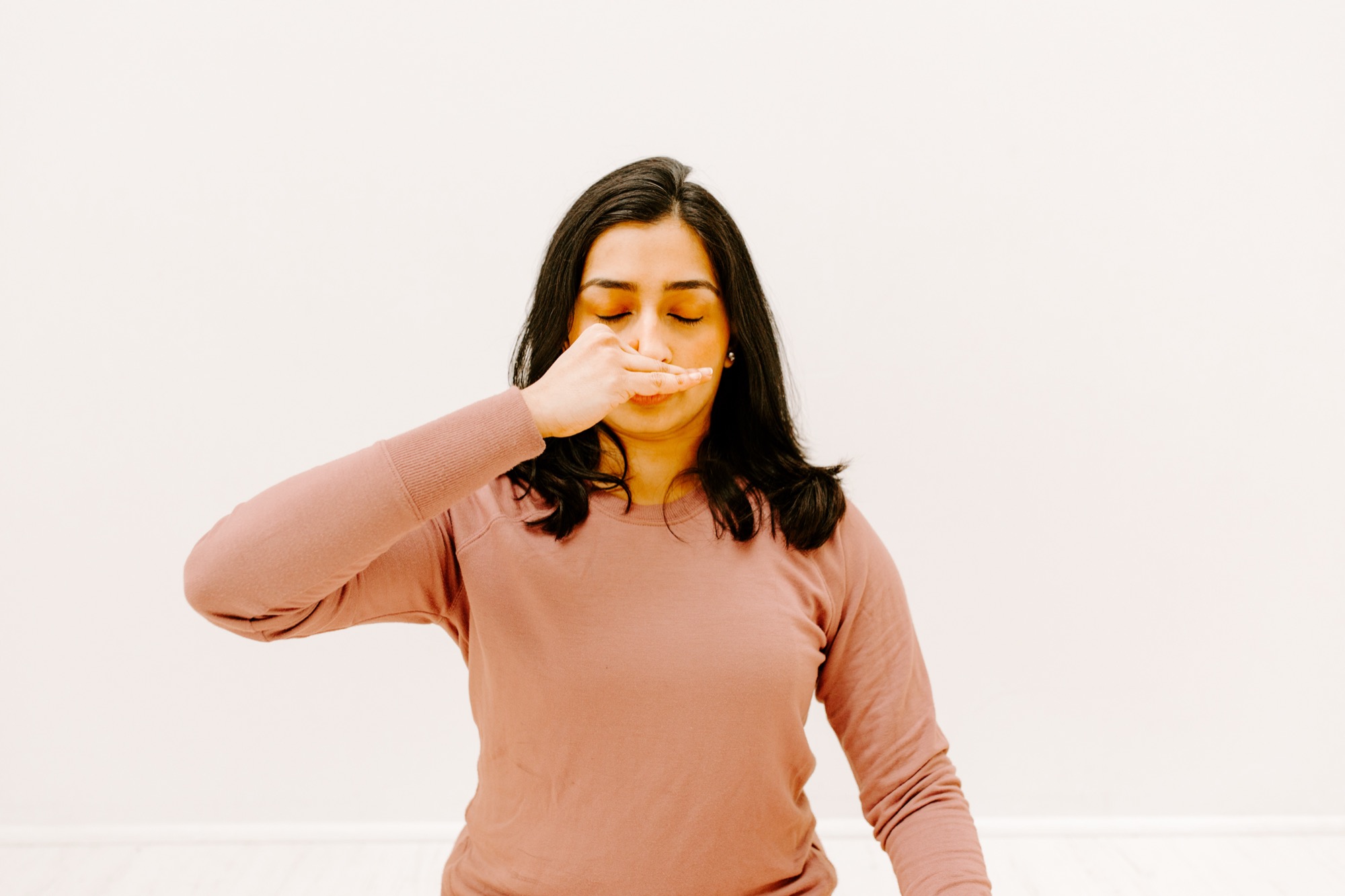 Arundhati Baitmangalkar practising alternate-nostril breathing, one hand at the nose, eyes closed.